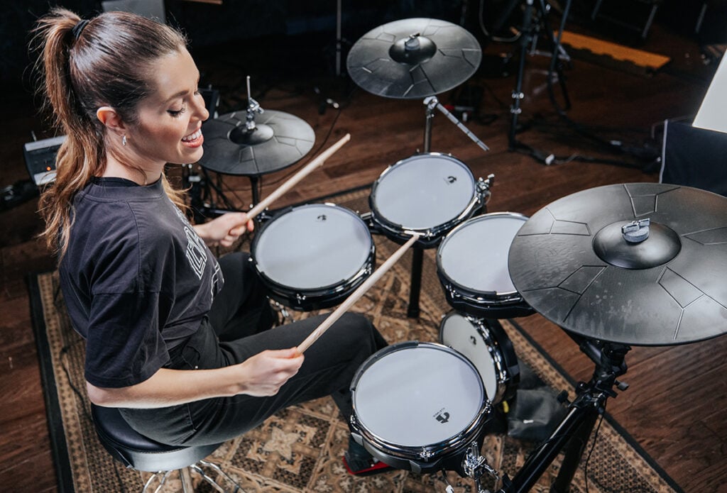 girl playing electronic drum set