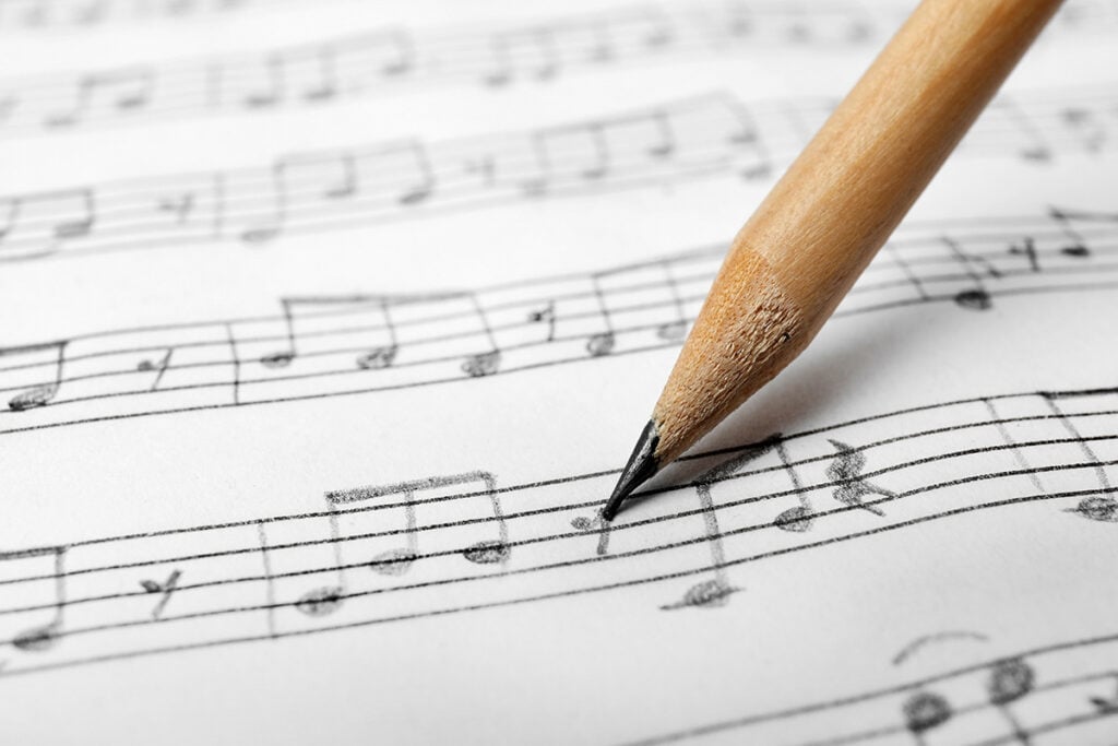 Sheet with music notes and pencil as background, closeup