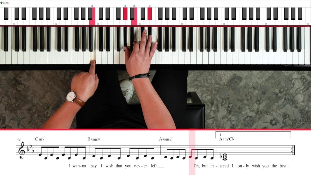 Overhead view of hands playing Wish You the Best with sheet music, chords, and highlighted keyboard.