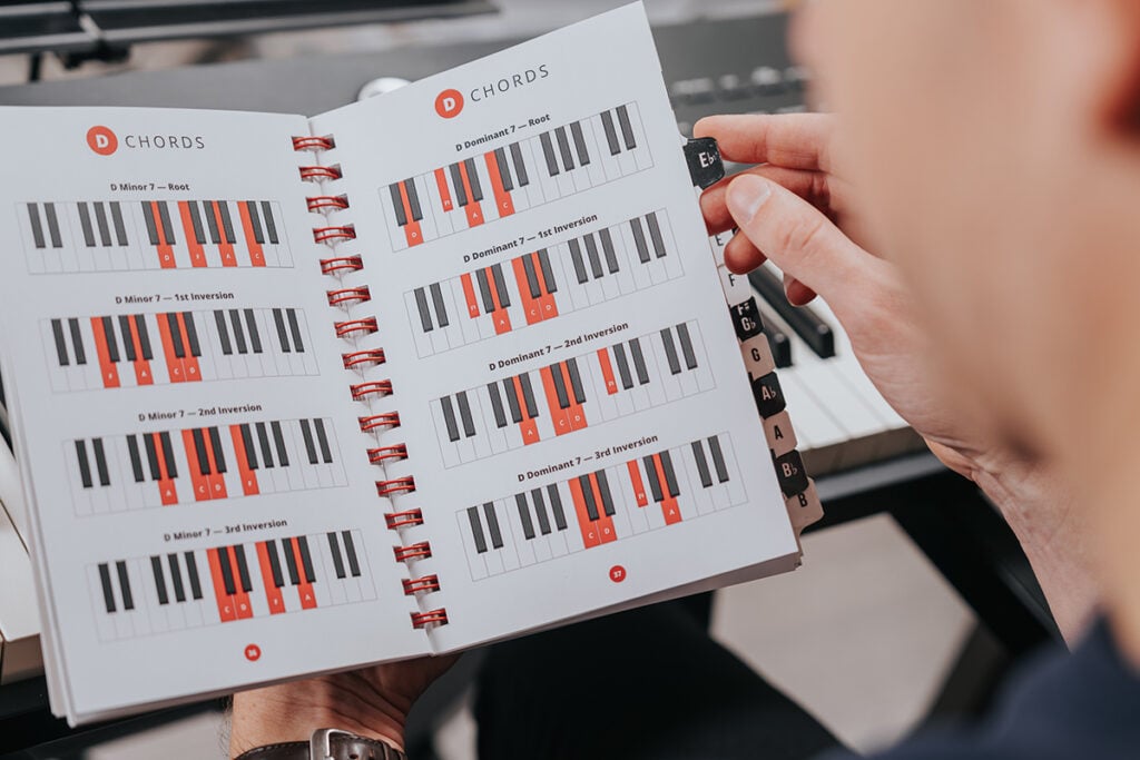 Hands opening book of chord diagrams.