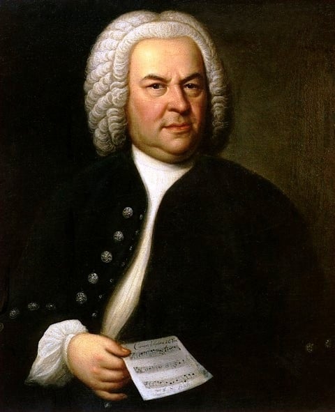 Baroque painting of man with white wig curls wearing suit jacket and holding piece of music.