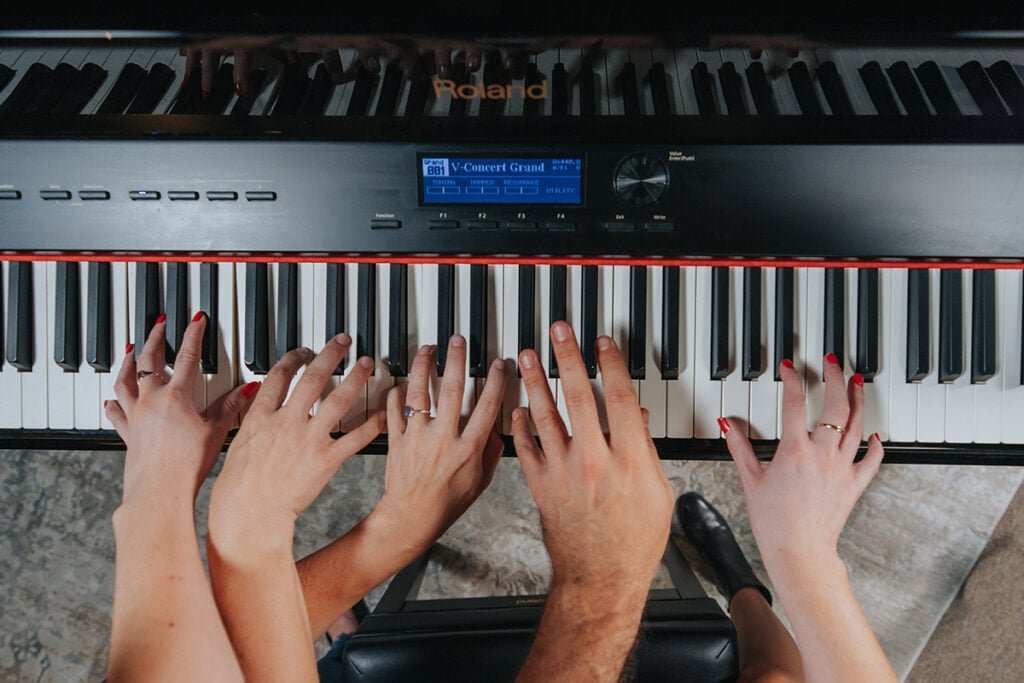 Overhead view of many hands on a keyboard.