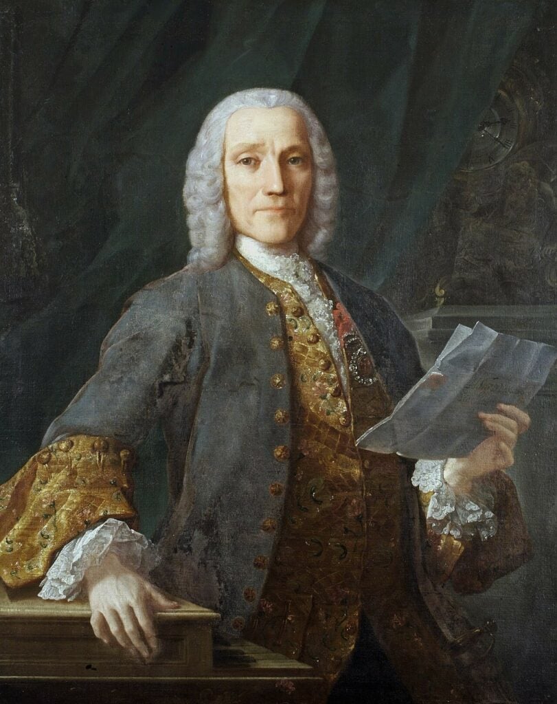 Painting of stately Baroque man with curly white wig in elaborate suit holding sheaf of paper in one hand.