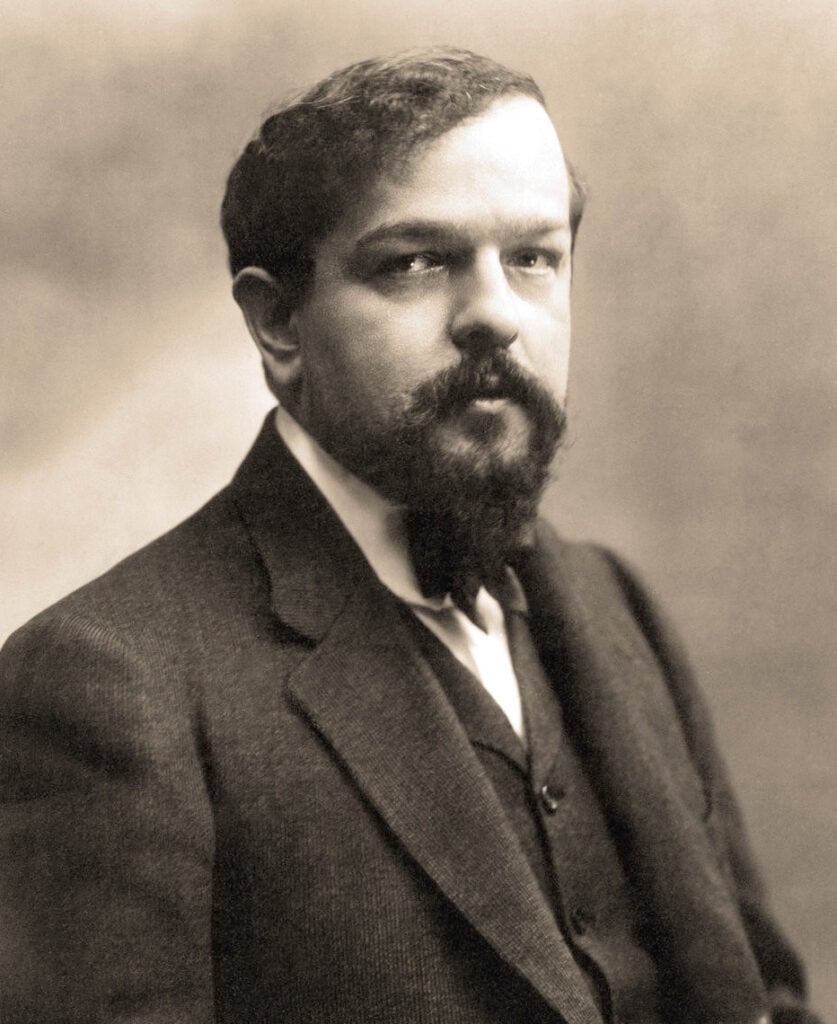Monotone photograph of man in suit with beard.