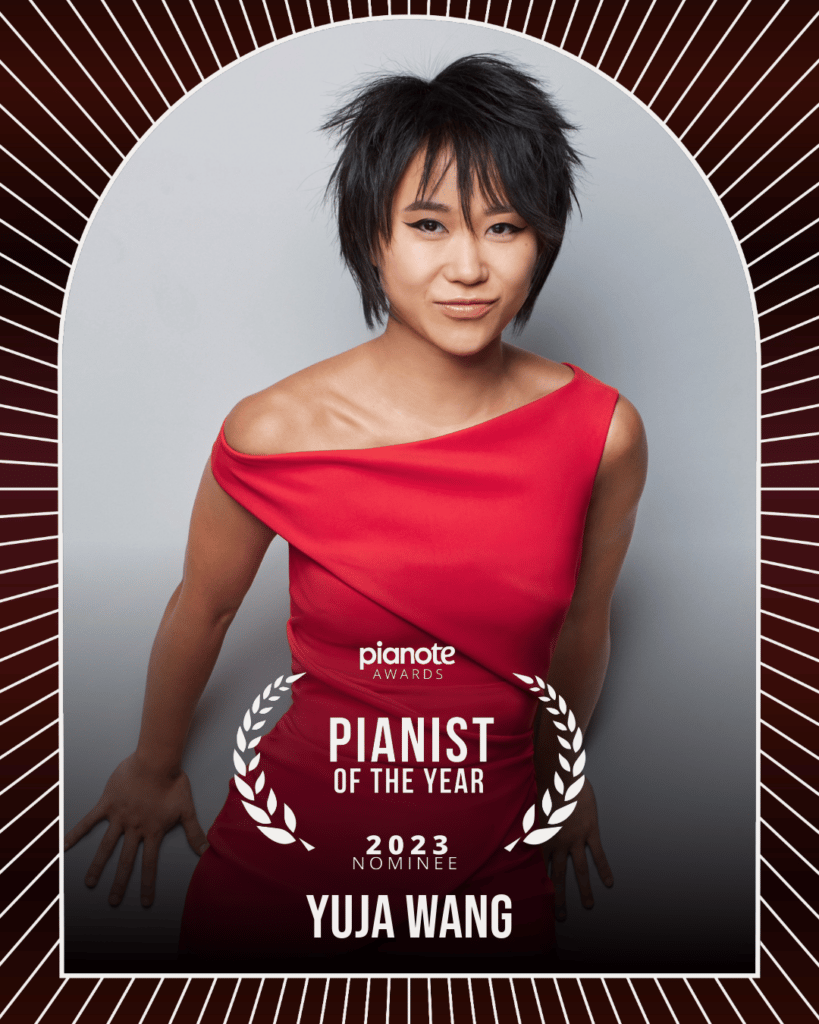 Yuja Wang. Woman in dark pink dress against white background with bob hairstyle.