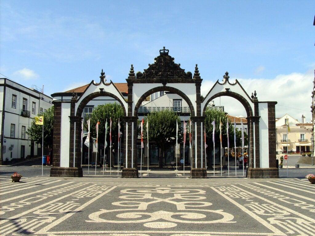 Large outdoor doorway in front of patterned cobblestone, high contrast architecture. 