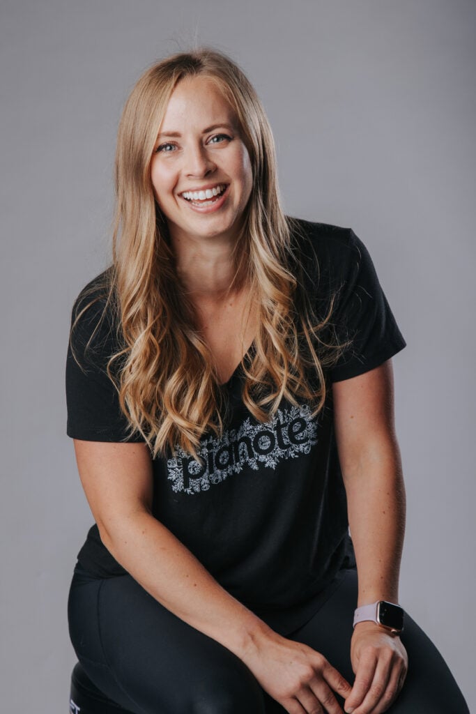 Woman with long blonde hair smiling in black Pianote T-shirt.