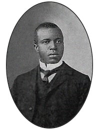 Black and white portrait of man in necktie and short cropped hair.