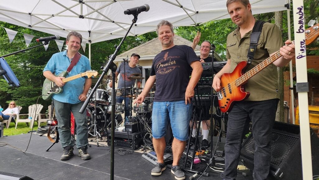 Marc's band playing in a tent at an outdoor event.