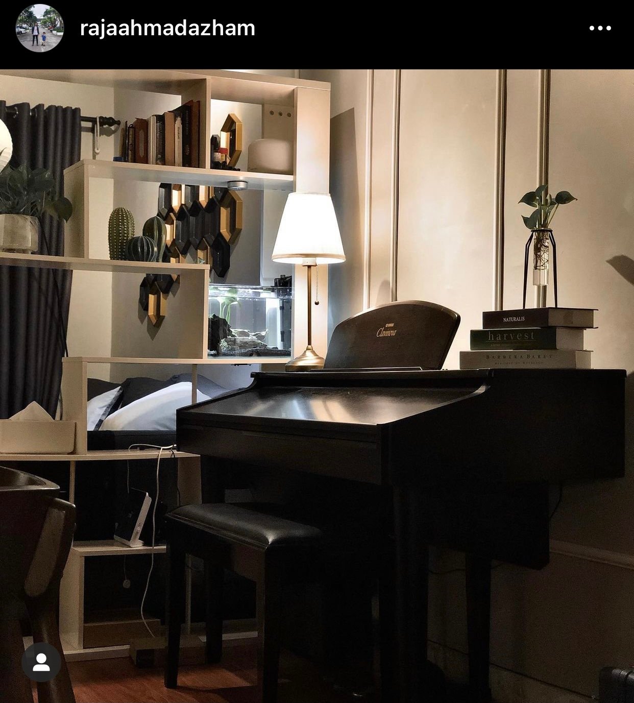 Clavinova piano in home next to divider shelf at night.
