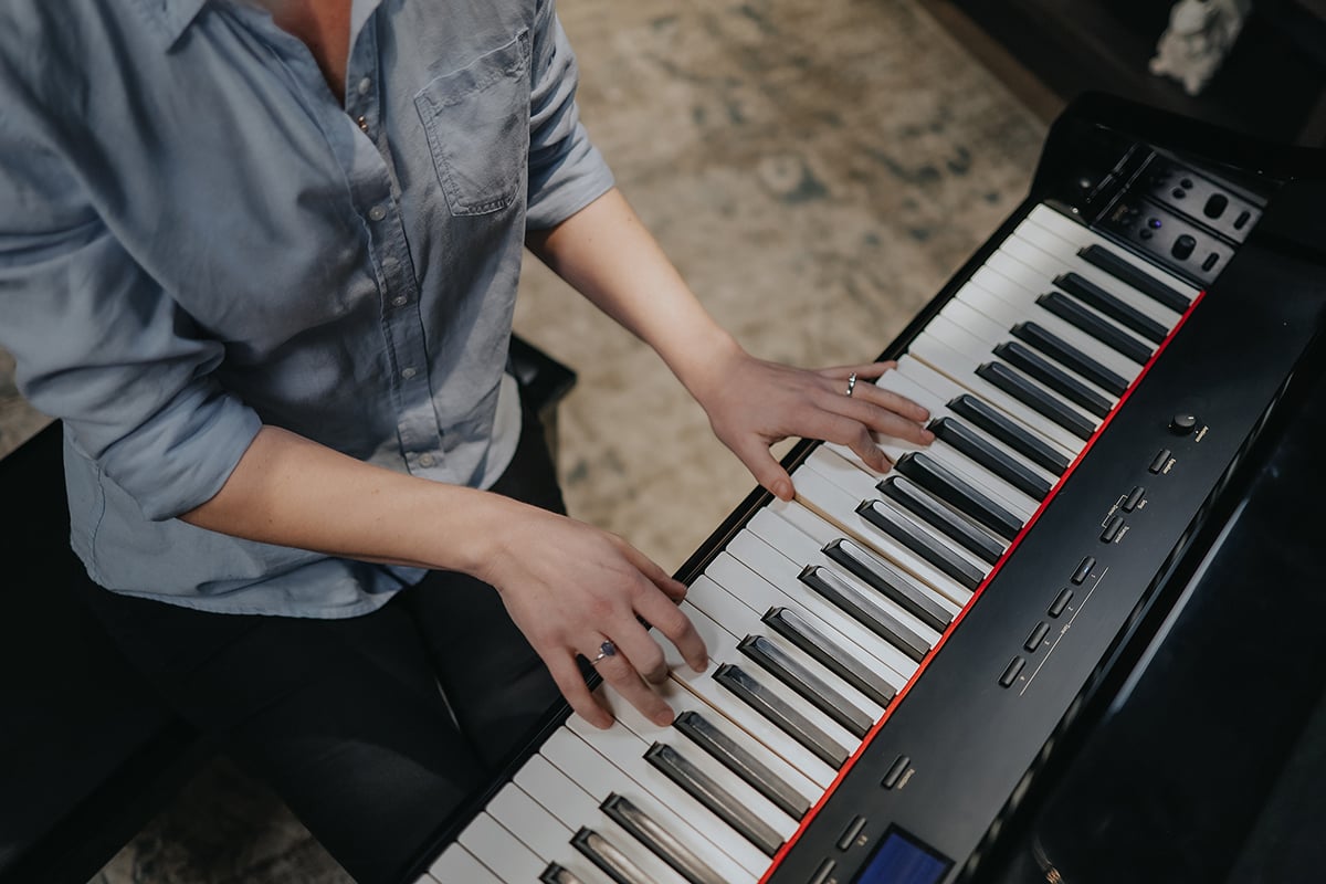 Bird's eye view at an angle of Lisa playing on studio piano.