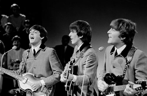 Black and white image of Paul, George, and John performing.