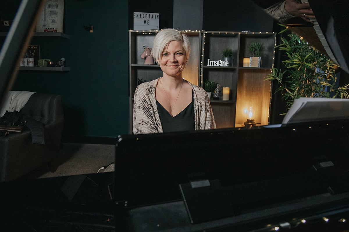 Lisa smiling behind the piano.