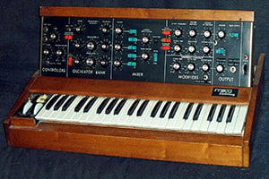 Old keyboard encased in wooden cabinet with vertical slab of switches.